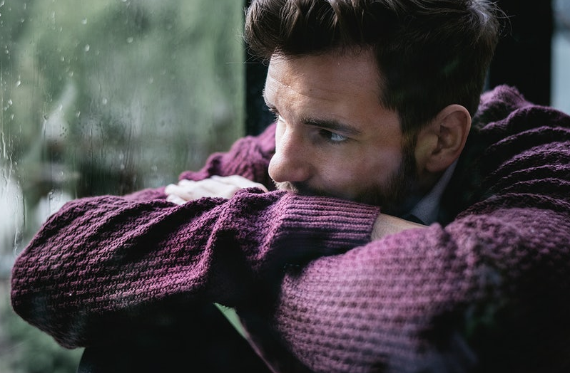 sad man looking through the window